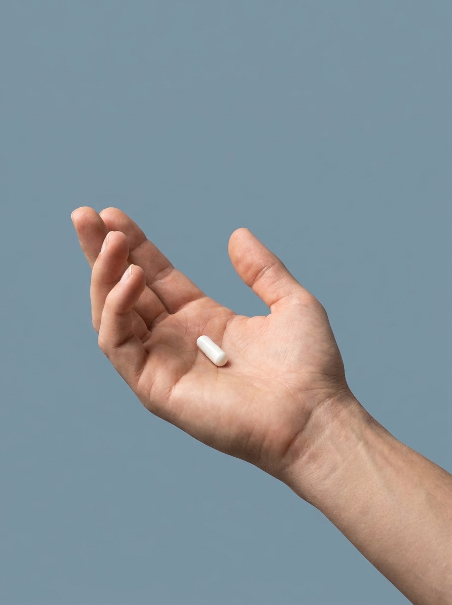 A single Man Power capsule held in an open palm