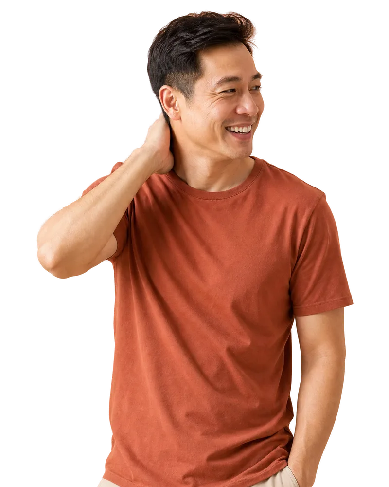 A man in a terracotta tee laughing toward someone off-frame on the BURN Protocol