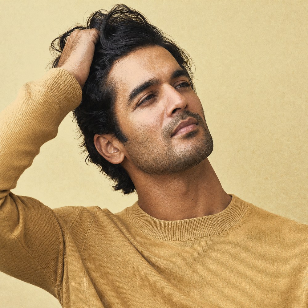 A man running his fingers through thick, healthy hair