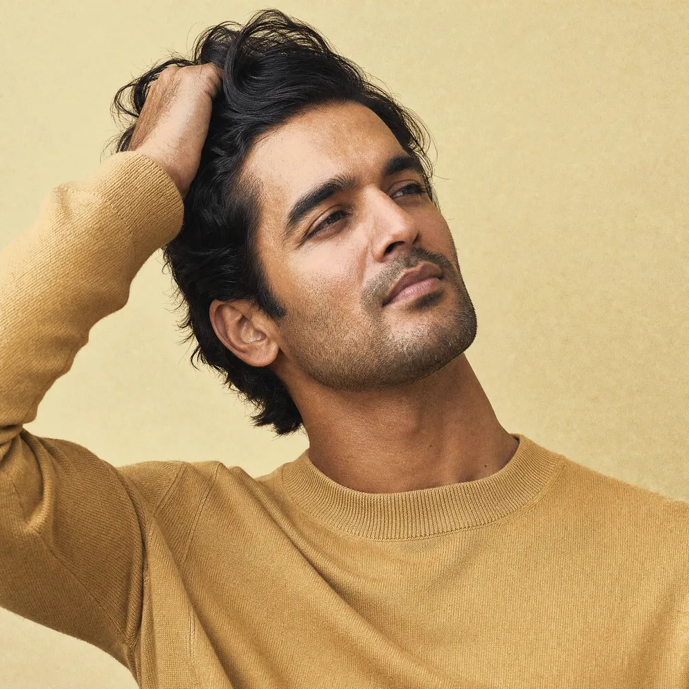A man running his fingers through thick, healthy hair