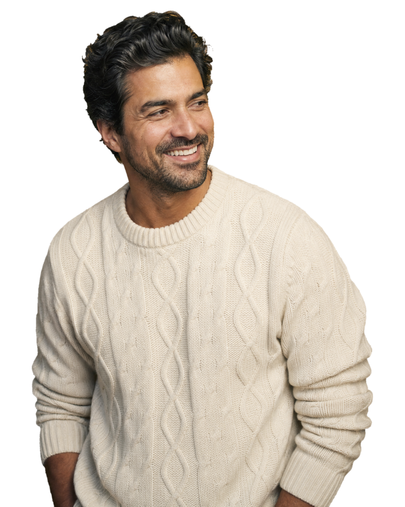 A smiling man with thick, healthy hair in a cream knit sweater on the CROWN Protocol